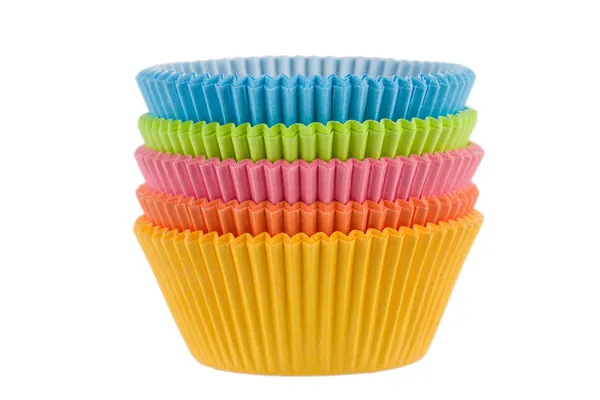 Bunte leere Muffin-Tassen auf weißem Hintergrund — Stockfoto