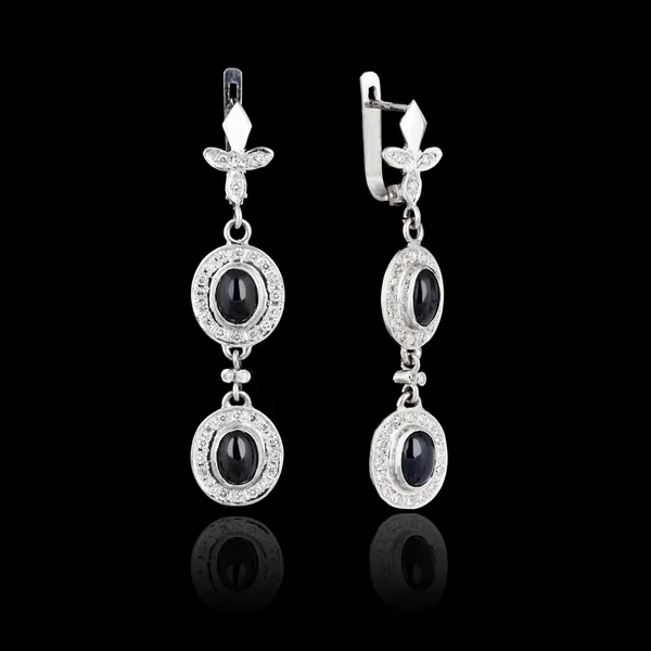 Boucles d'oreilles en or blanc isolé sur fond noir — Photo