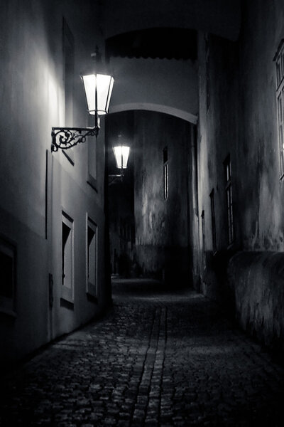 Mysterious narrow alley with lanterns in Prague at night