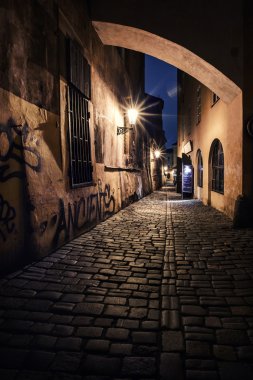 Narrow alley with lanterns in Prague at night