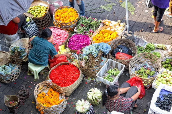 Balinese woman in market sell flower petals and fruits for everyday offering — Stock Photo, Image