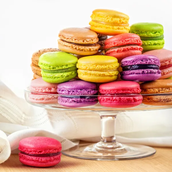 French colorful macarons in a glass cake stand — Stock Photo, Image