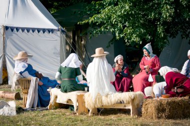 Ortaçağ kadın oturuyor ve kampta sohbet