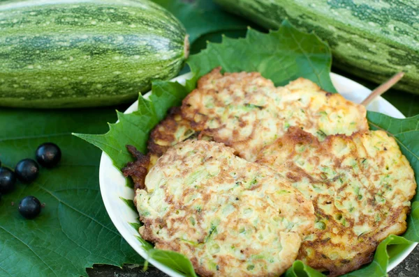 Pancakes with fresh zucchini on grape leaves — Stock Photo, Image