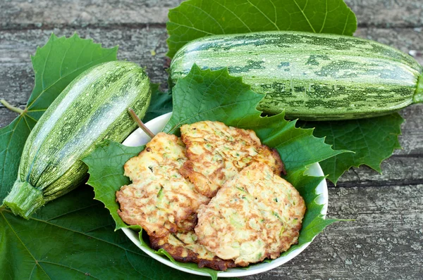 Pancakes with fresh zucchini on grape leaves — Stock Photo, Image