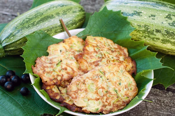 Frittelle con zucchine fresche su foglie d'uva — Foto Stock