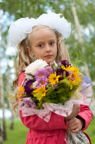 Schoolgirl dressed with a bouquet — Stockfoto