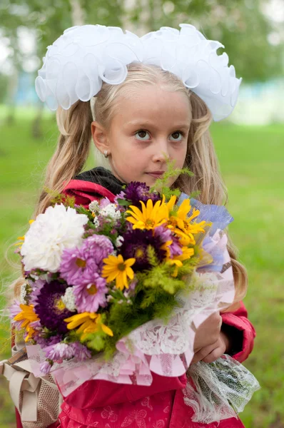 Schoolgirl dressed with a bouquet — Stockfoto