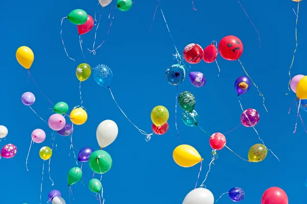 Kleurrijke ballonnen op een blauwe lucht achtergrond — Stockfoto