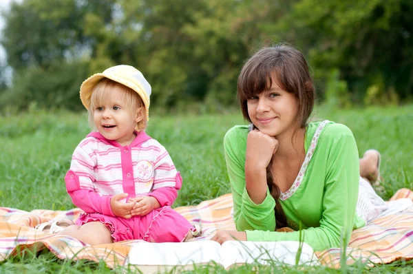 Two sisters reading a book outdoors — Stock Photo, Image