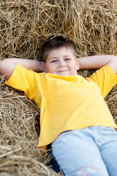 Мальчик лежит на соломе — стоковое фото