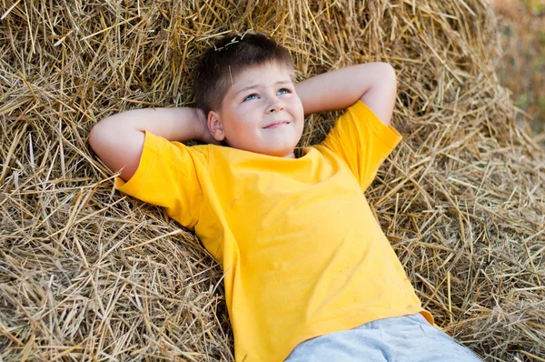 Jongen liggend op het stro — Stockfoto