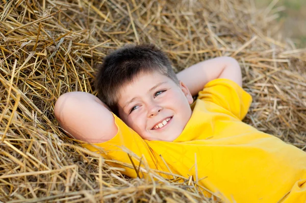 Boy lying on the straw — Stock Photo, Image