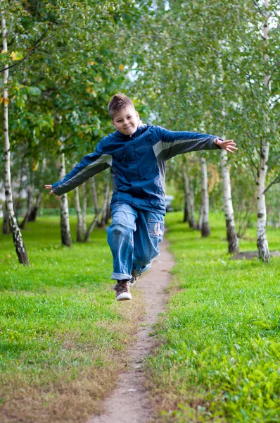 Niño saltando en un bosque de abedules —  Fotos de Stock