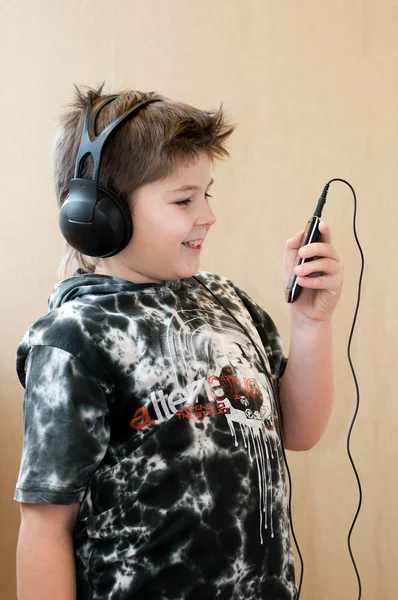 Niño escuchando música con auriculares — Foto de Stock