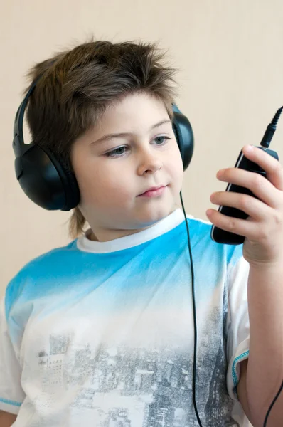 Niño escuchando música con auriculares — Foto de Stock