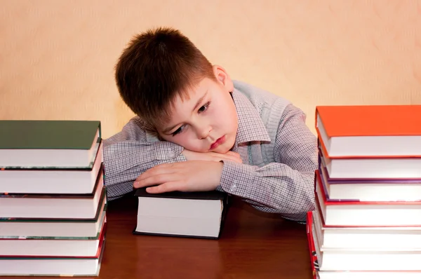 Bambino stanco con una pila di libri — Foto Stock