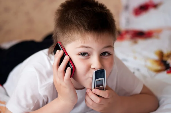 Niño jugando en los teléfonos celulares — Foto de Stock