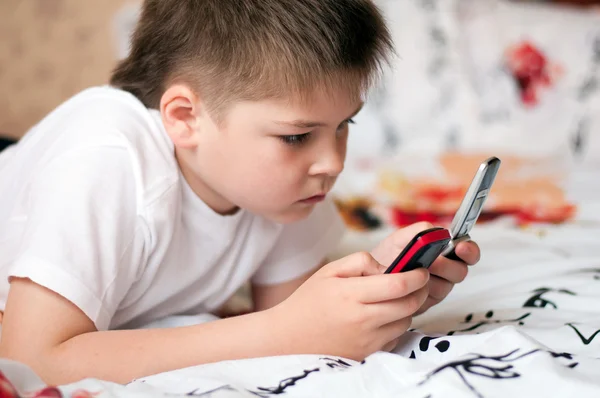 Niño jugando en los teléfonos celulares — Foto de Stock