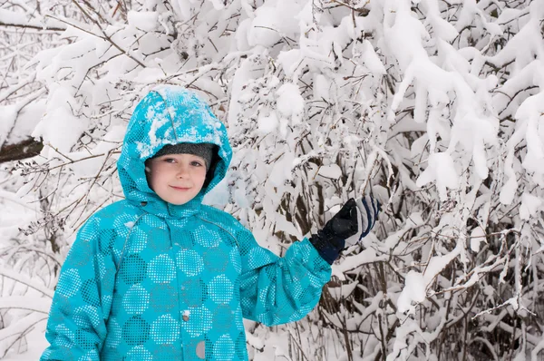 Junge in einem verschneiten Wald — Stockfoto