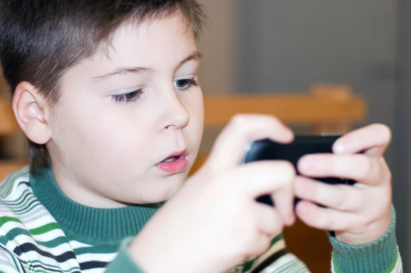 Niño jugando en un teléfono celular — Foto de Stock