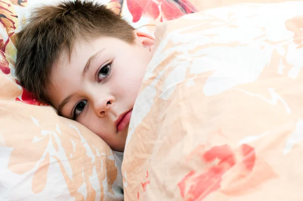 Хворий хлопчик лежить у ліжку — стокове фото