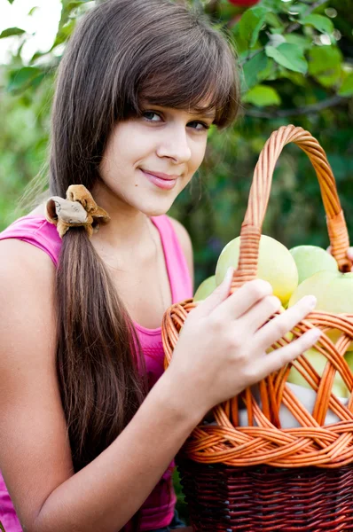 Menina adolescente com uma cesta de maçãs — Fotografia de Stock
