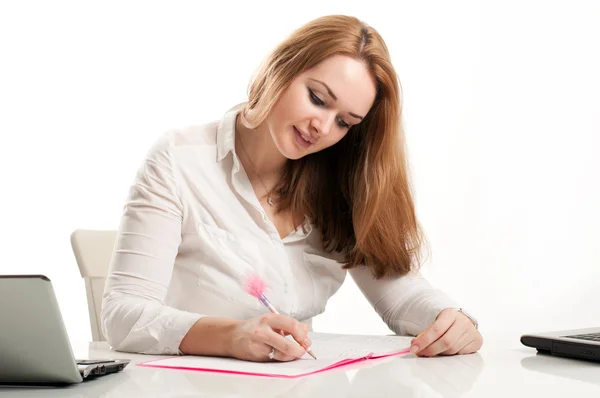 Zakenvrouw zit aan een bureau in een kantoor met een notitieblok openen — Stockfoto