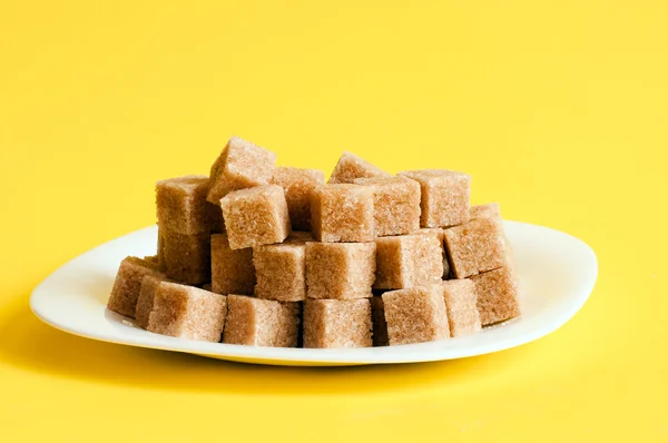 A sárga háttér finomítatlan cukor — Stock Fotó