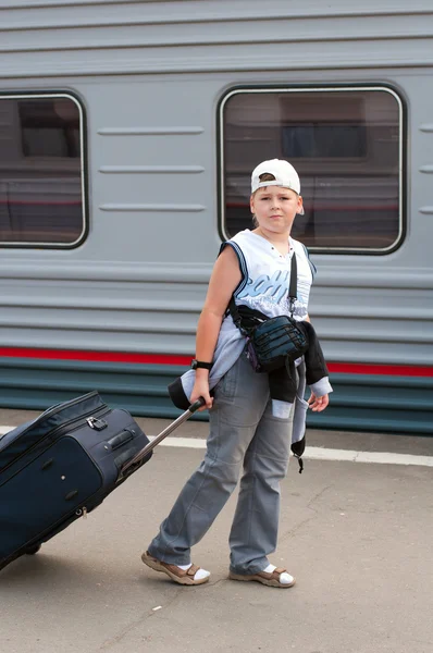 Boy with travel bag near the train — Stock Photo, Image