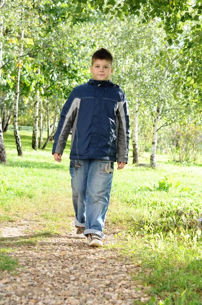 El chico está en un camino en el parque — Foto de Stock