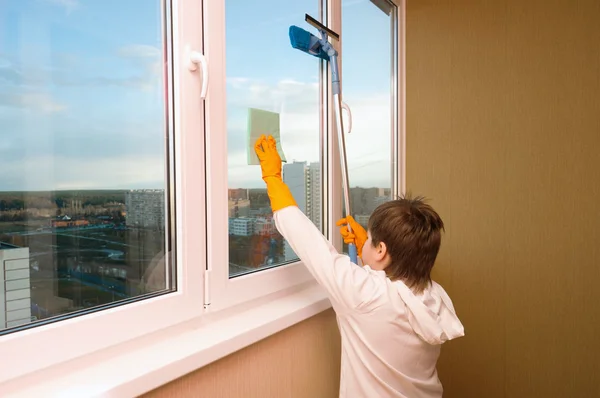 Un chico lava una ventana — Foto de Stock