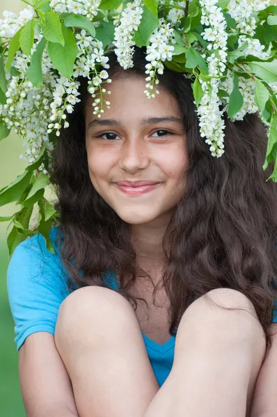 Tiener meisje met een krans van kersenbloesem op haar hoofd — Stockfoto