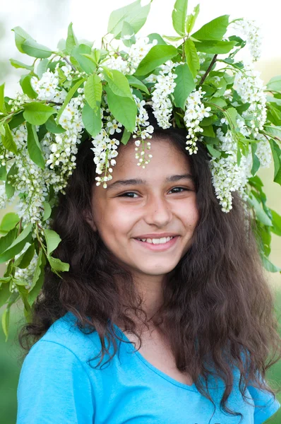 Teen flicka med en krans av körsbär blommar på hennes huvud — Stockfoto