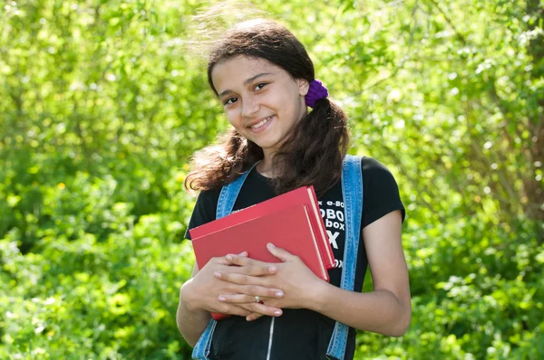 Teen girl with books on nature — Stock Photo, Image