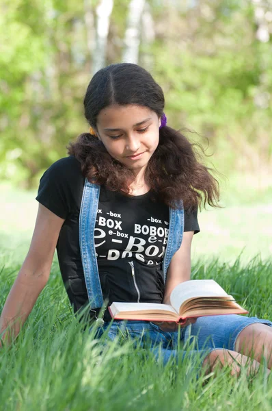 Chica adolescente leyendo un libro sobre la naturaleza —  Fotos de Stock