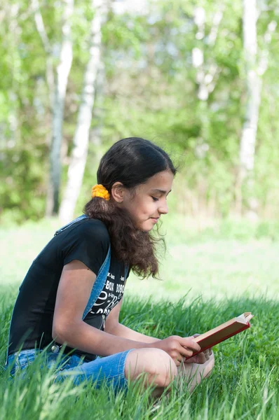 Chica adolescente leyendo un libro sobre la naturaleza —  Fotos de Stock