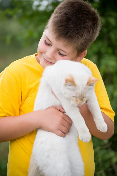 Niño con un gato blanco — Foto de Stock