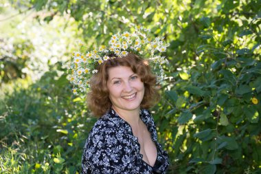 bir kadınla başında papatyalardan bir çelenk