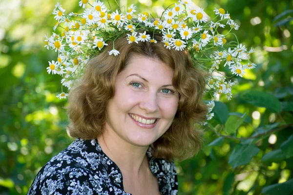 Una donna con una corona di margherite in testa — Foto Stock