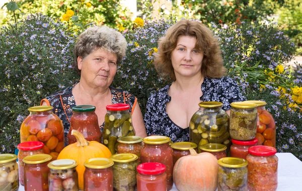 Två kvinnor och hem konserverade grönsaker — Stockfoto