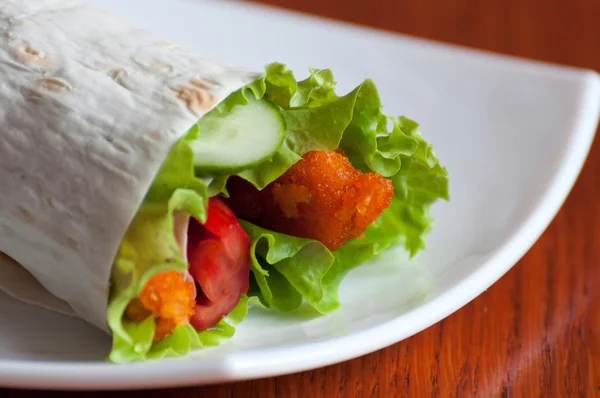 Rouleau avec des doigts de poisson dans une pita — Photo