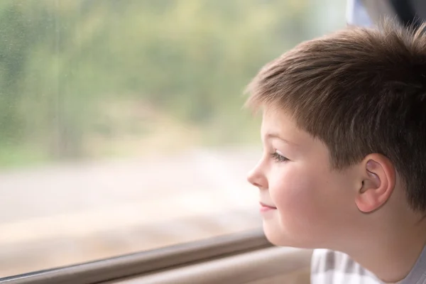De jongen kijkt in trein venster — Stockfoto
