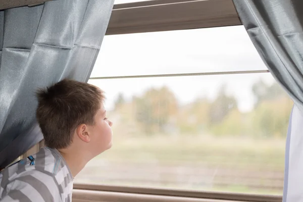 El chico mira en la ventana del tren — Foto de Stock