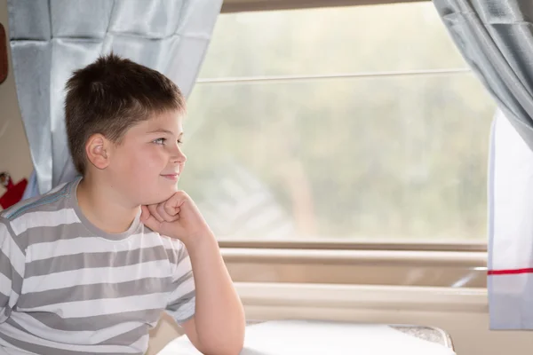 The boy looks in train window — Stock Photo, Image