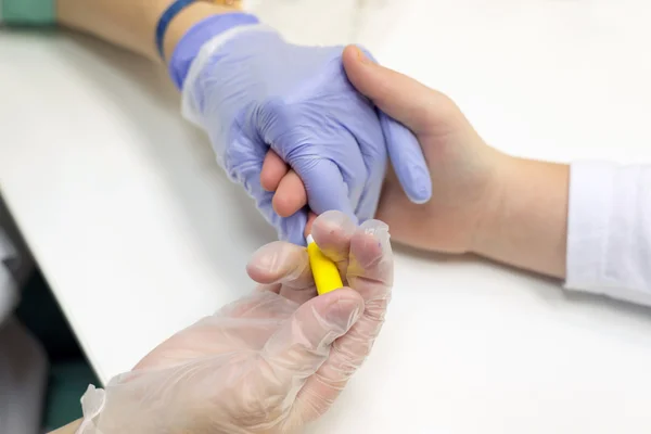 Taking blood from a finger on the analysis — Stock Photo, Image