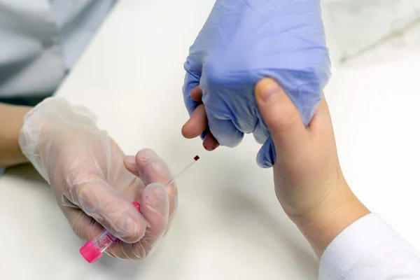 Taking blood from a finger on the analysis — Stock Photo, Image