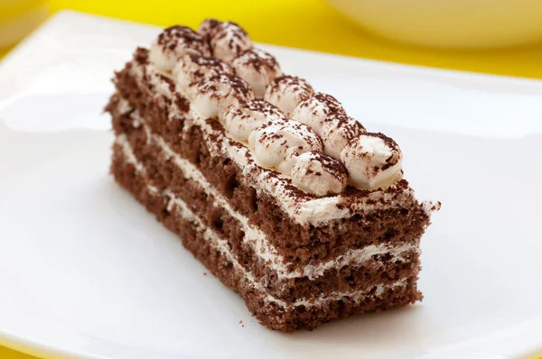 黄色の背景上のチョコレート ケーキ — ストック写真