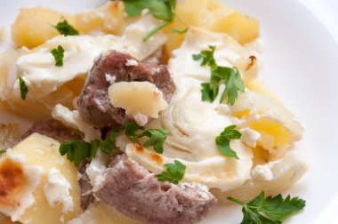 gebakken aardappelen met vlees in een romige saus