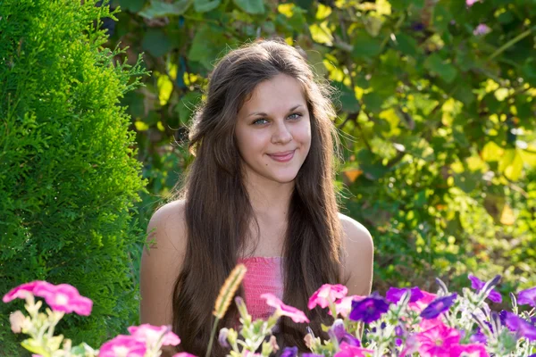 Teenager-Mädchen auf einem Hintergrund von Blumen — Stockfoto